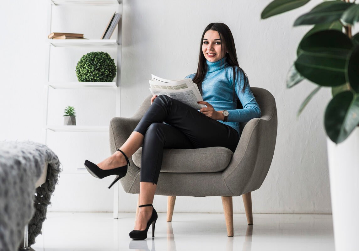 smiling-woman-with-newspaper-armchair